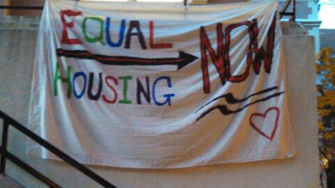 Hand-painted sign reading "Equal Housing Now" in reference to gender non-specific housing at UNC-Chapel Hill